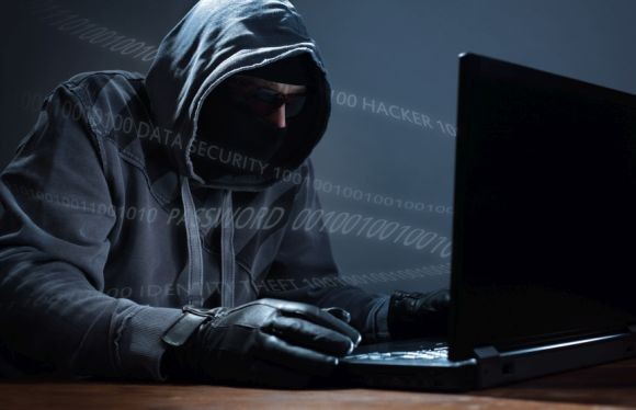 Hacker stealing data from a laptop